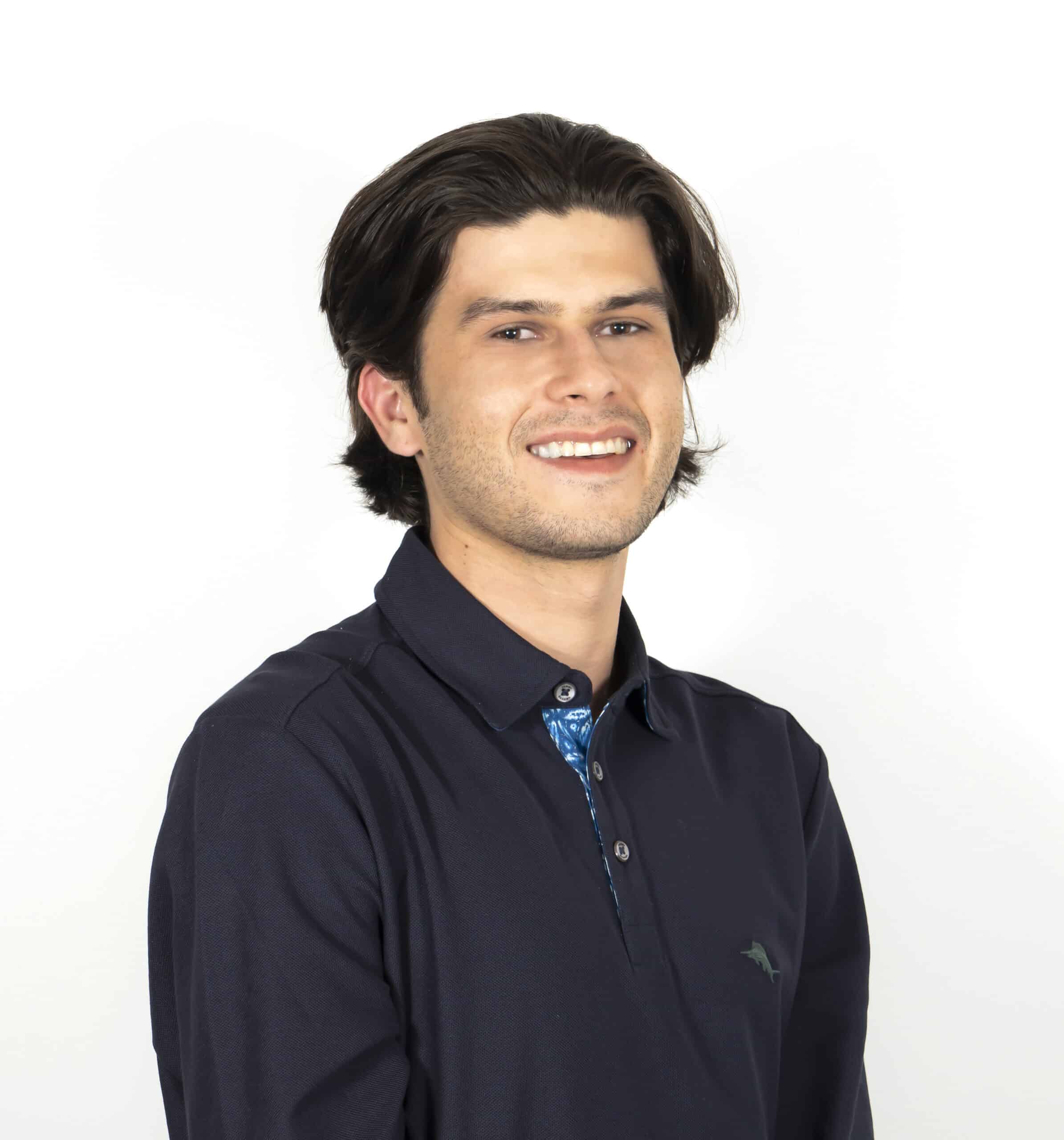 Headshot of a man with shoulder-length hair, wearing a light button-down shirt