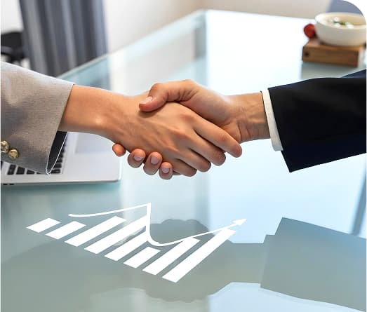 Business handshake over financial graphs on a glass table