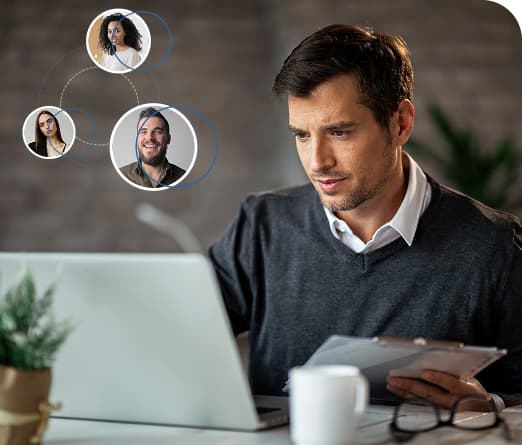 Man working on a laptop with virtual video call icons above him